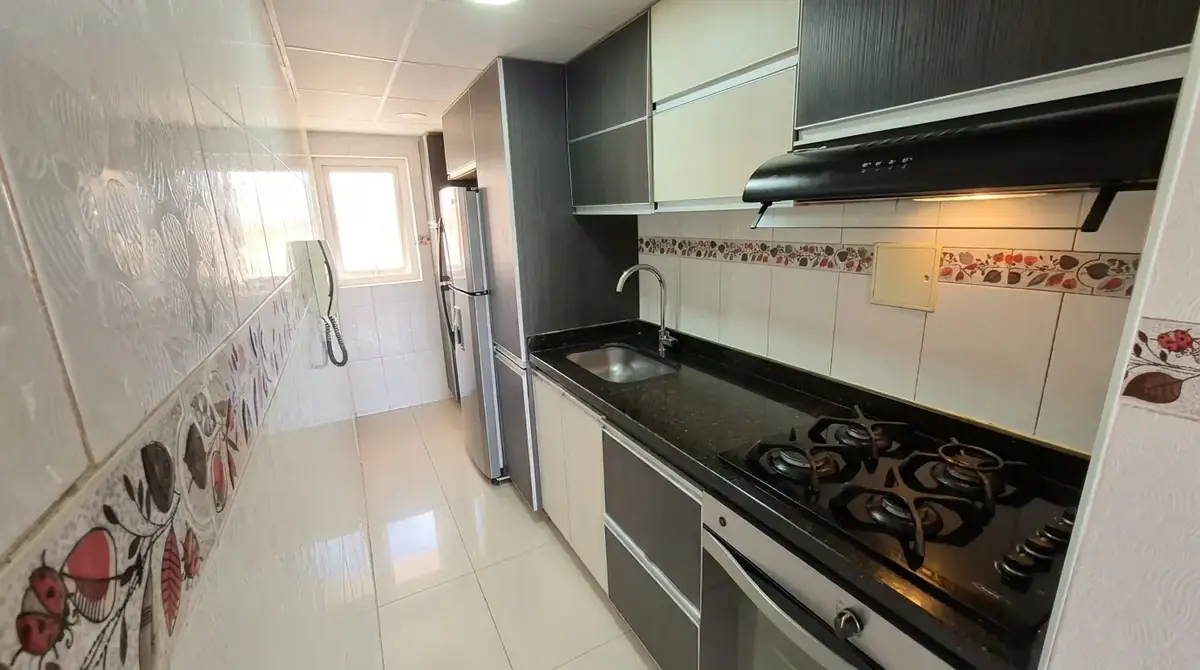 Cocina con estufa de gas y mesón en granito